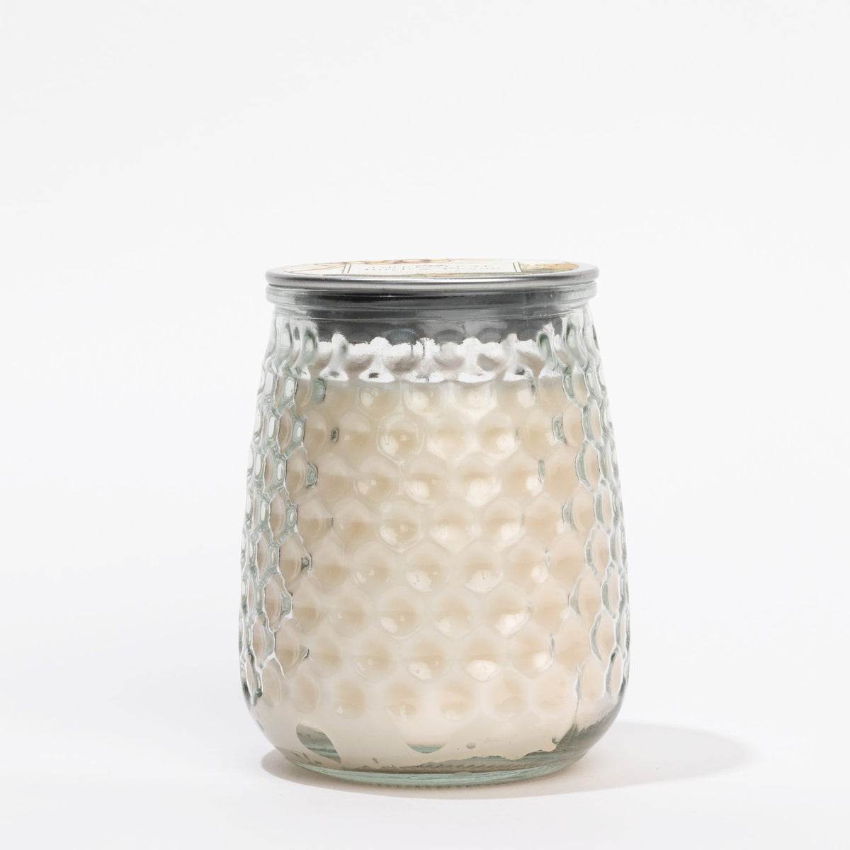 Glass candle holder with textured surface on a white background