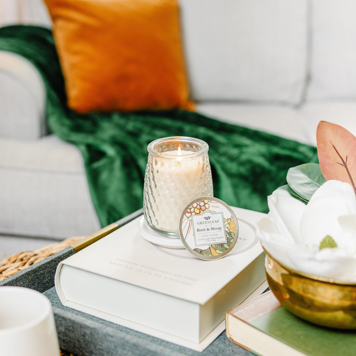 Candle on books with decorative elements on a table