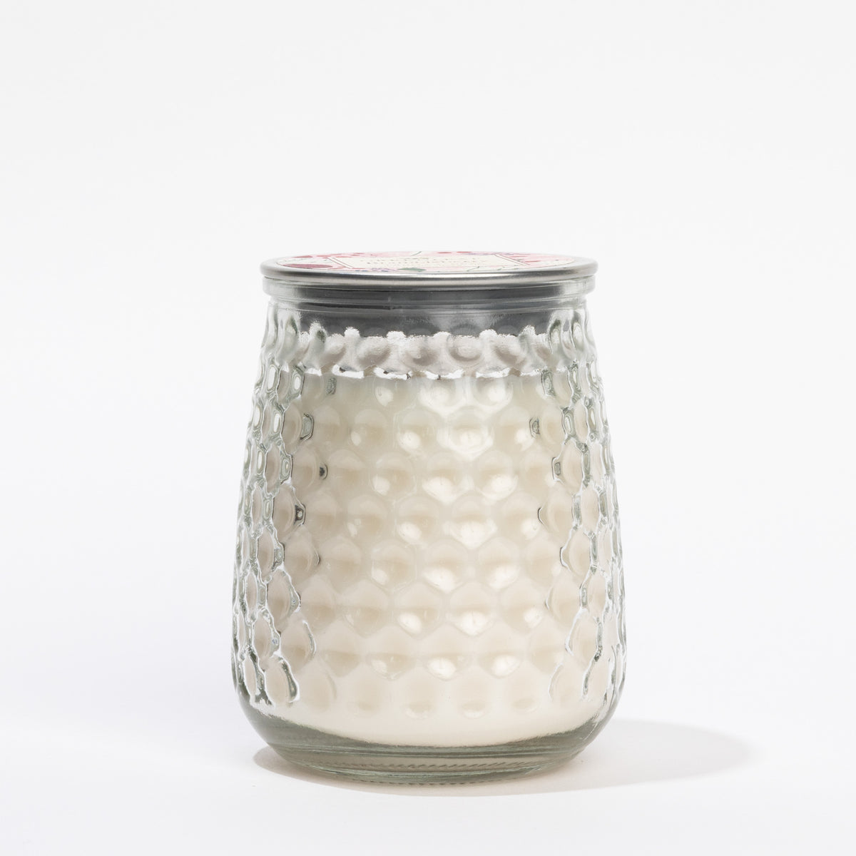 Glass candle holder with textured surface on a white background
