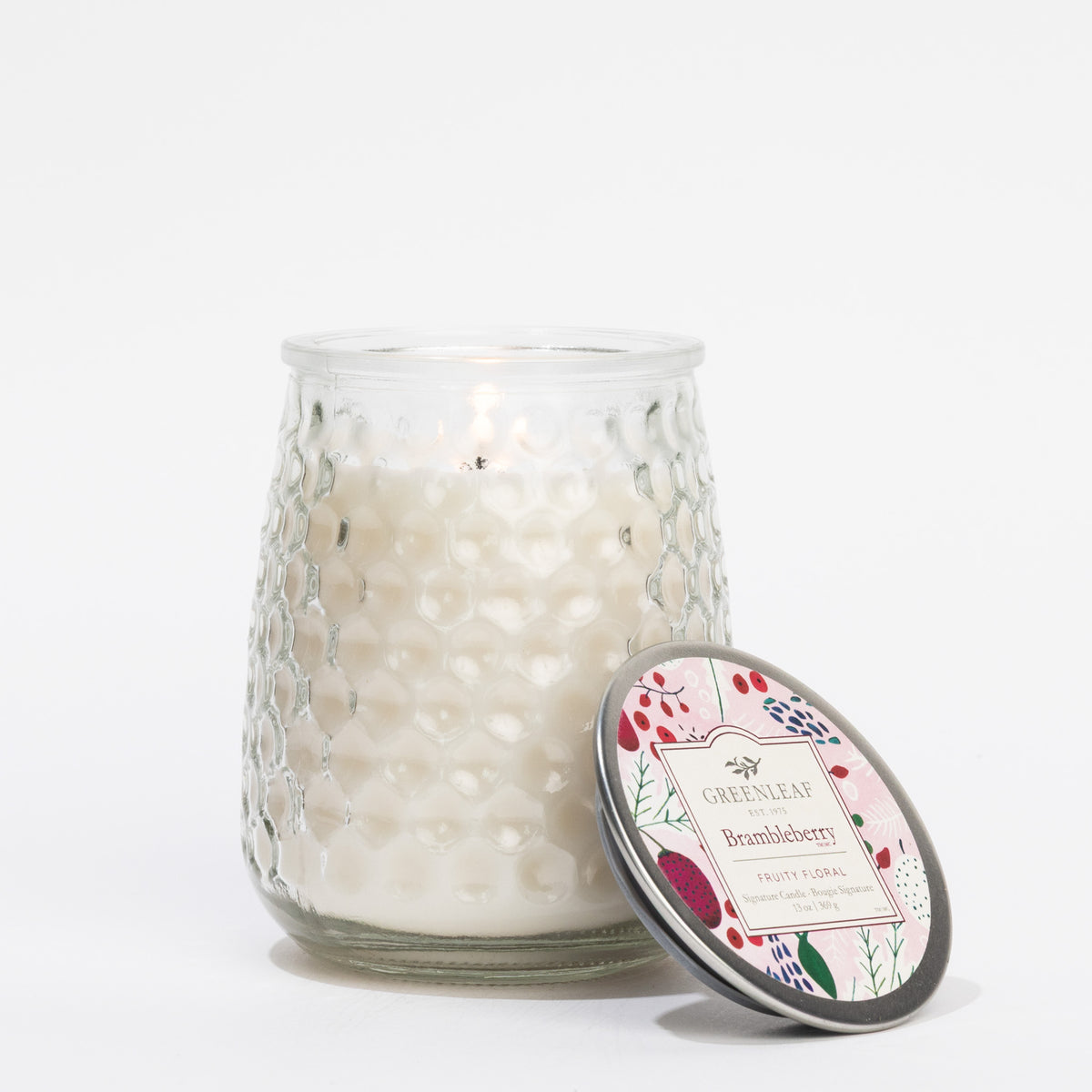 Glass candle with decorative lid on a white background