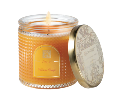 Candle in a glass jar with a decorative lid on a white background