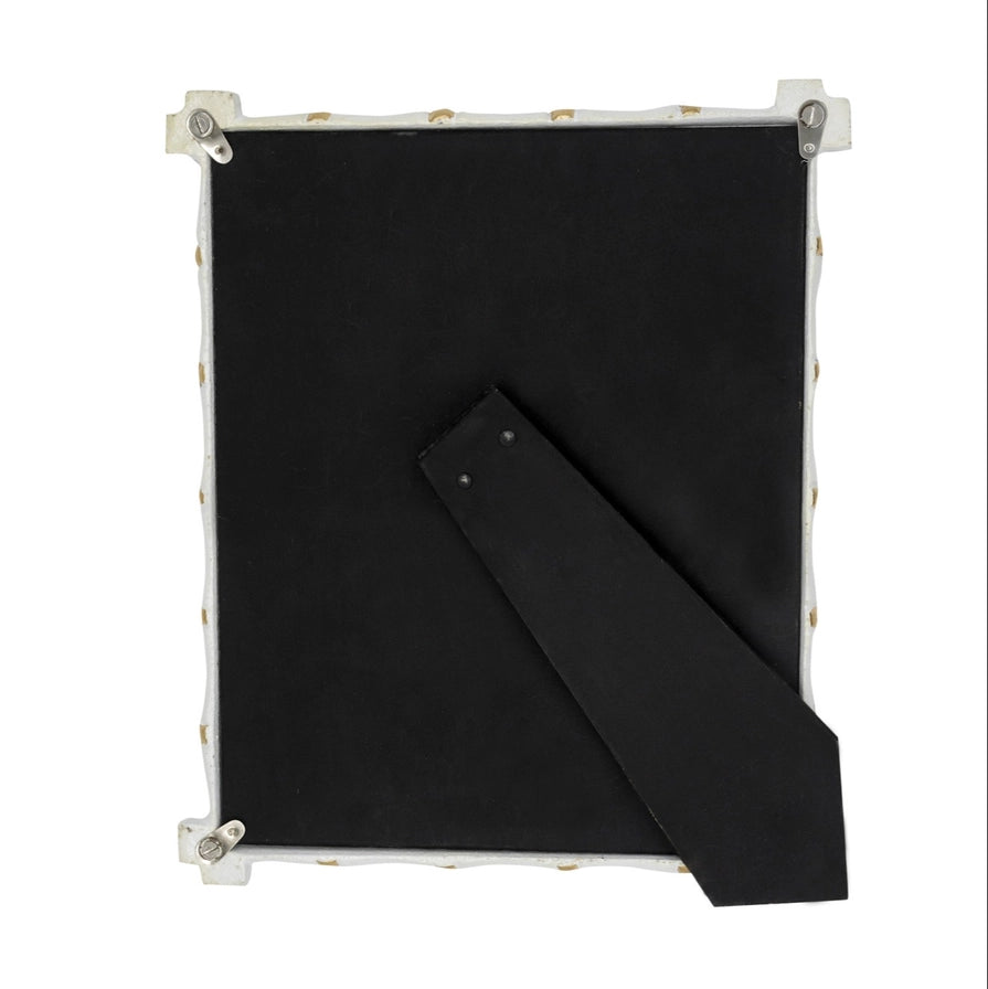 Black back of a white frame with gold accents on a white background