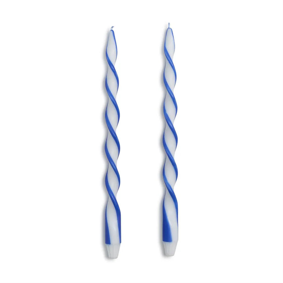Two blue and white twisted candles on a white background