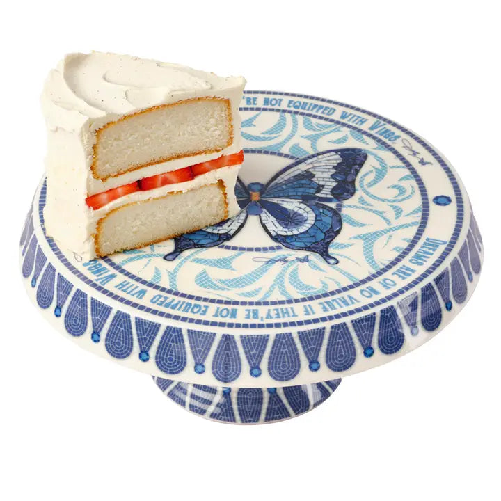 A piece of cake on a Blue and White Cake Stand with a Butterfly Design on a white background