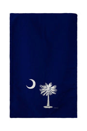 Navy blue towel with white palm tree and moon design on a white background