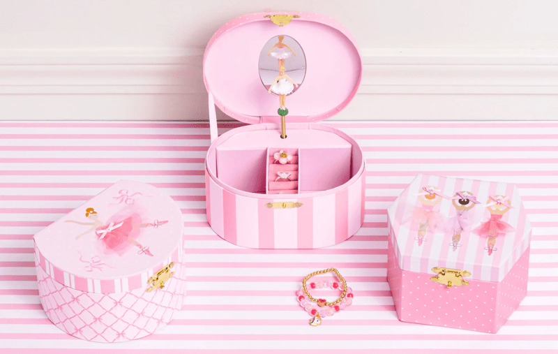 Pink jewelry box with accessories on a striped pink and white background