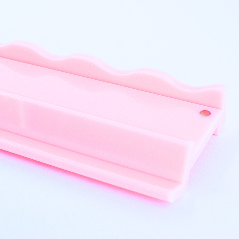 Close-up of pink mahjong pusher on a pink rack on a light pink background