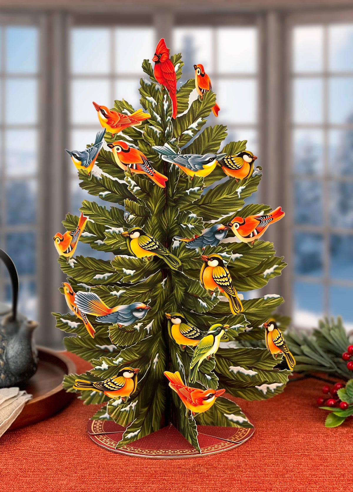 Decorative Christmas tree with colorful birds on a red surface