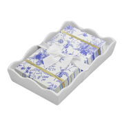 blue floral pattern guest paper napkins and white bow in wavy ceramic napkin holder on a white background 