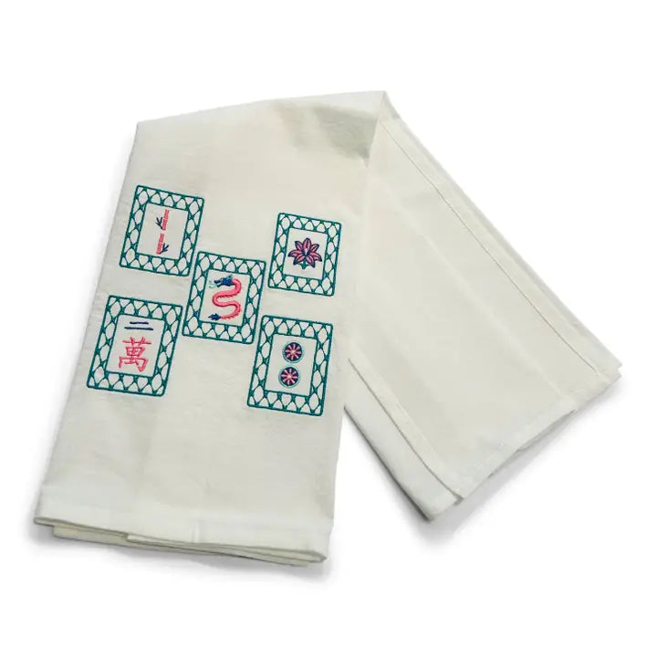 Folded white towel with embroidered designs on a white background