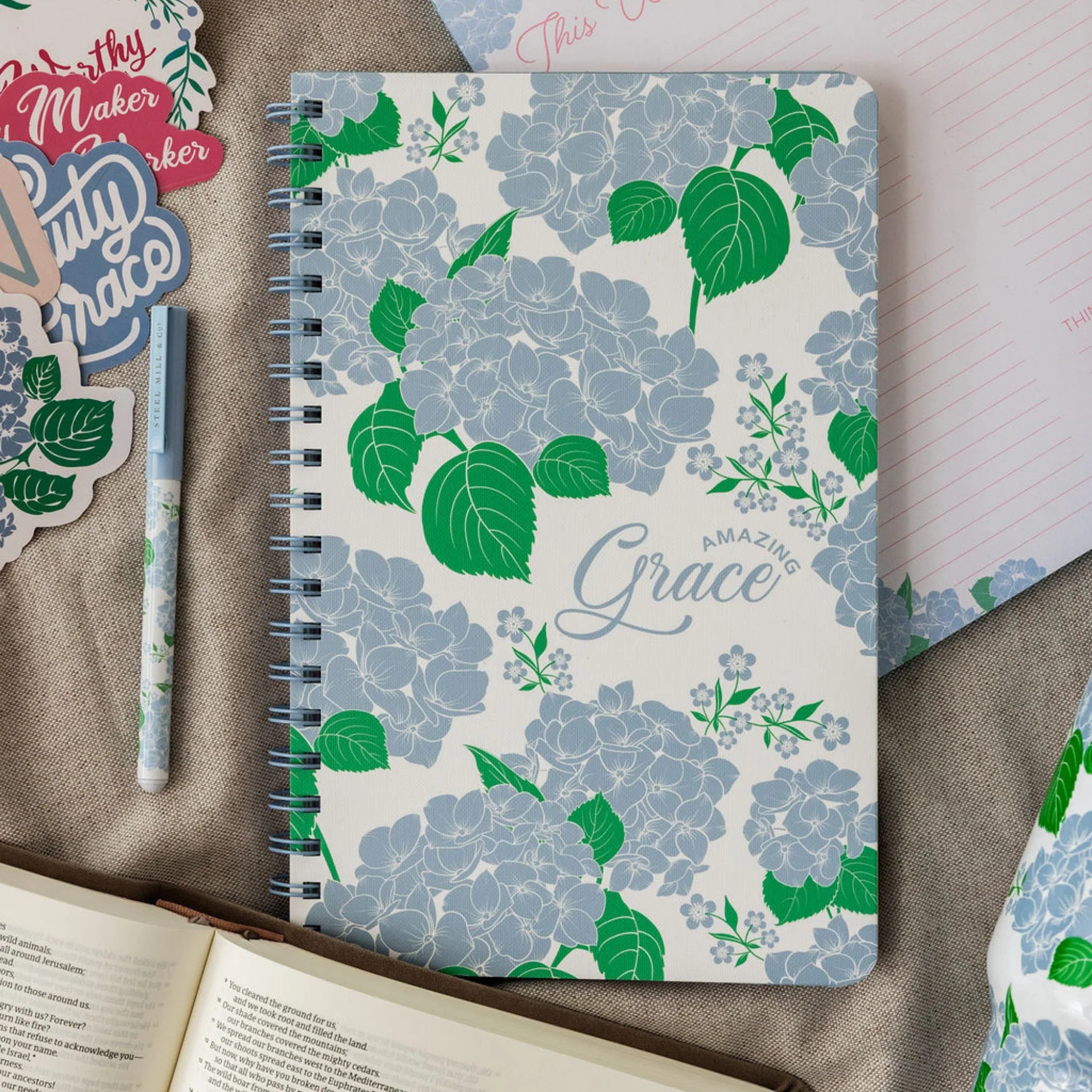 Notebook with floral design and 'Amazing Grace' text on a textured surface.