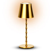 Gold table lamp with a bamboo-style base on a white background