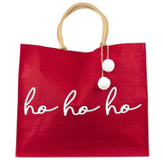 Red tote bag with 'ho ho ho' text and pom-pom details on a white background