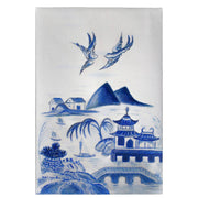 Decorative tile with blue and white landscape design featuring mountains, buildings, and birds.