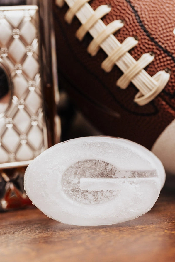 Football and a white stone with a logo on a wooden surface