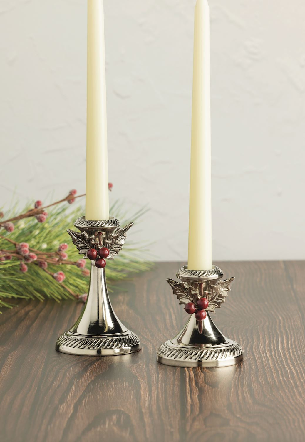 Seasonal - Holly Candlestick - Large - Aluminum - set of 2 on a table with ivory taper candles 