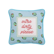 Decorative needlepoint pillow with olive patterns and text 'extra dirty please' on a light blue background