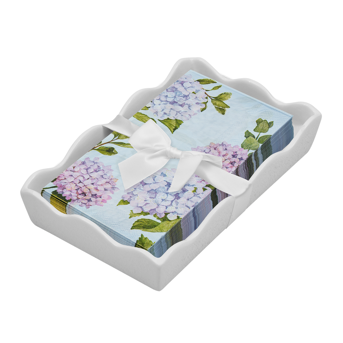 dinner size napkins by Sophistaplate that have hydrangea patternin light blue, lavender and green on a white scalloped tray with white rbbon and bow on a dark background