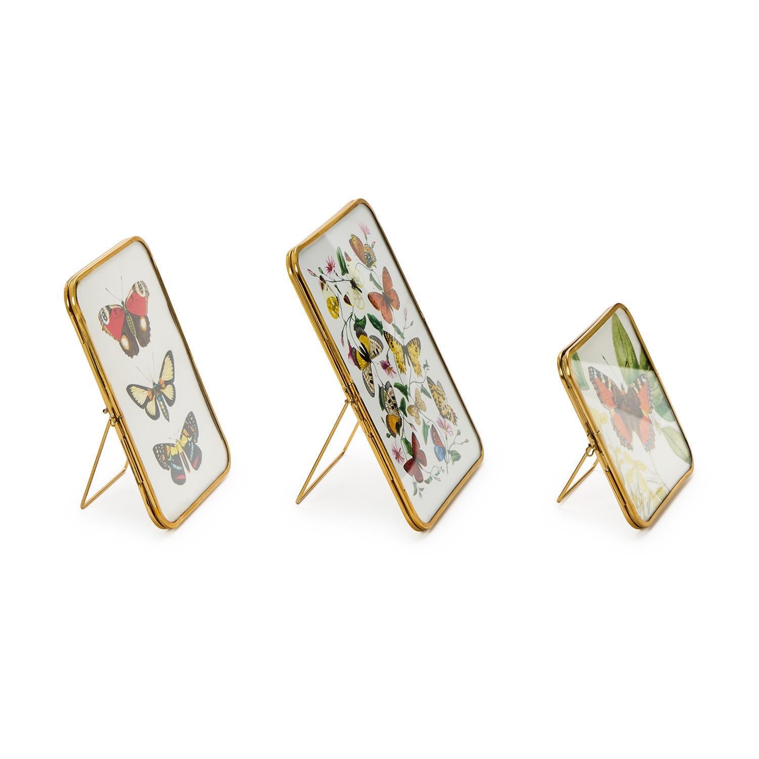Three decorative panels with butterfly designs on stands against a white background