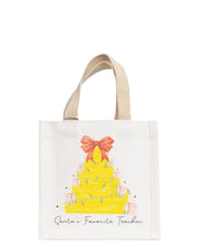 An off-white jute tote bag with beige woven handles, featuring a hand-drawn illustration of a yellow pencil Christmas tree with a pink bow and the text 'Santa's Favorite Teacher' printed below.