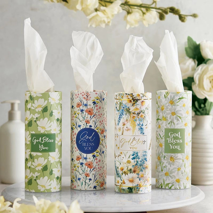 Four floral-patterned tissue boxes on a marble surface with a blurred background.