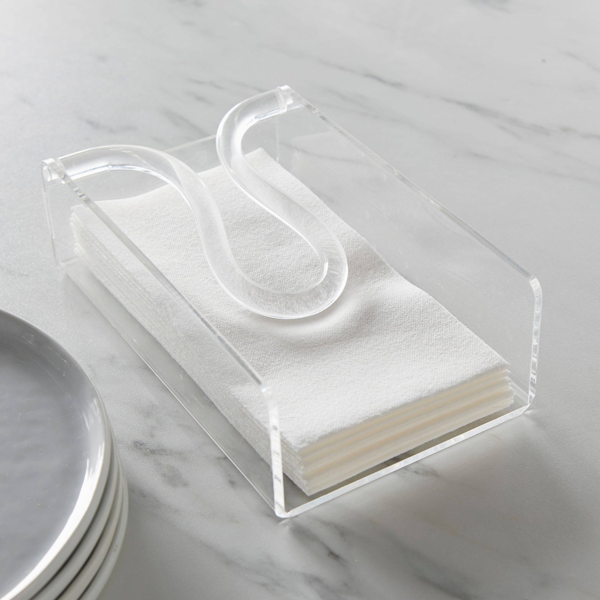 Huang Acrylic Brand Clear acrylic guest size napkin holder with white napkins on a marble surface