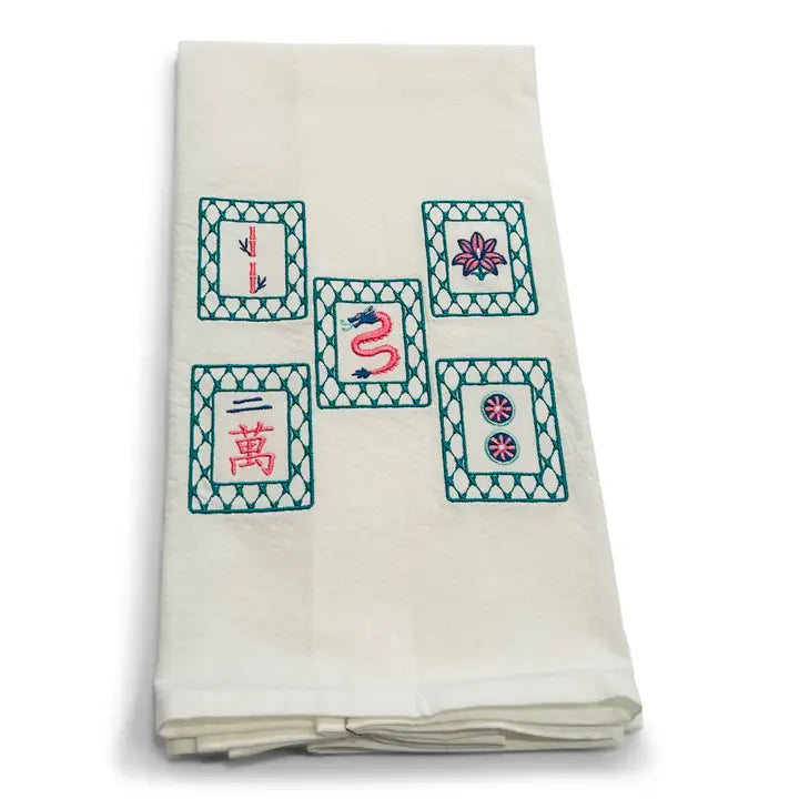 Folded white fabric with embroidered designs on a white background