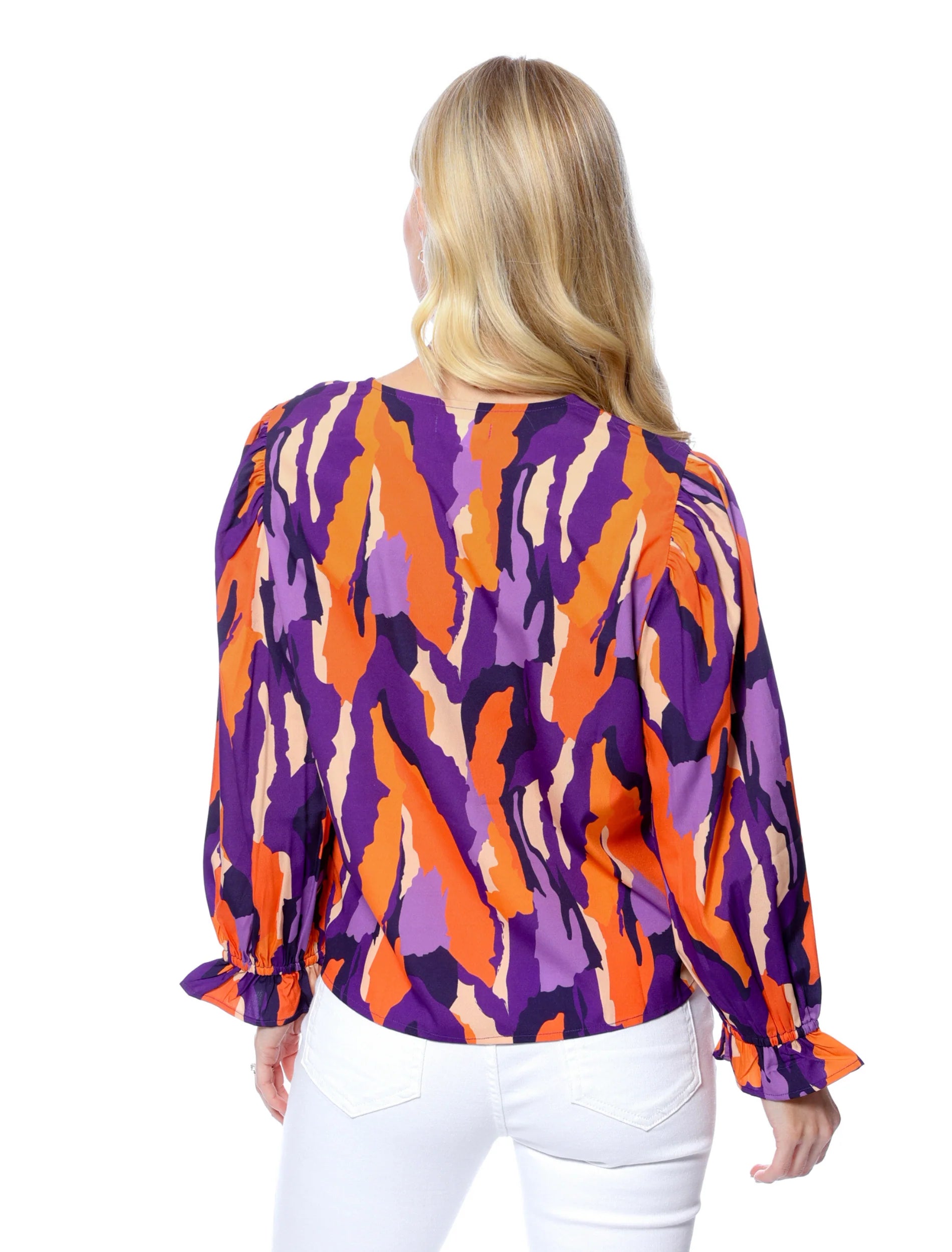 Woman wearing a colorful patterned blouse on a white background