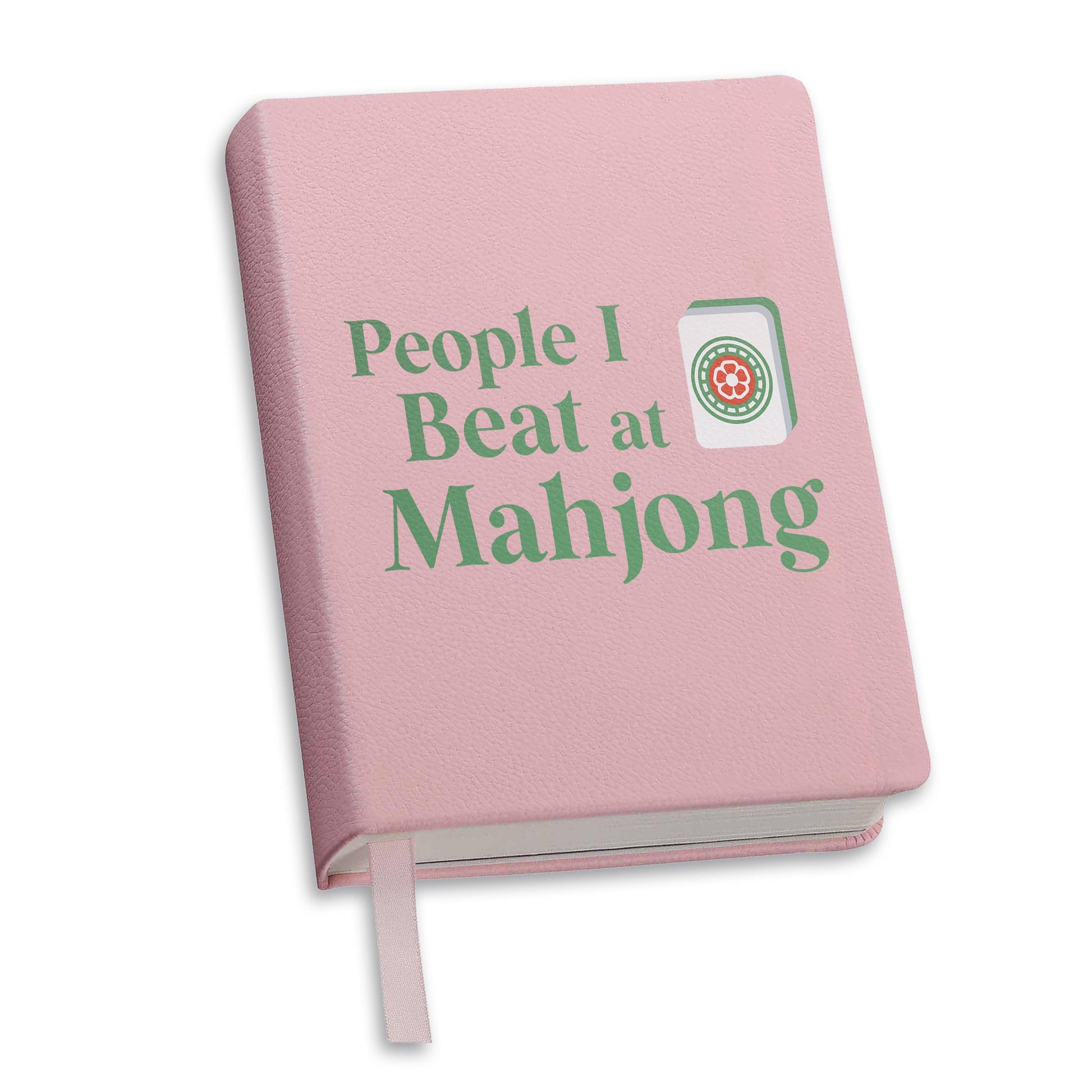 Toss designs Brand Pink notebook journal with 'People I Beat at Mahjong' text and Mahjong logo on a white background