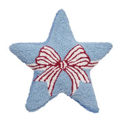 Star-shaped blue pillow with a red and white bow in the center on a white background