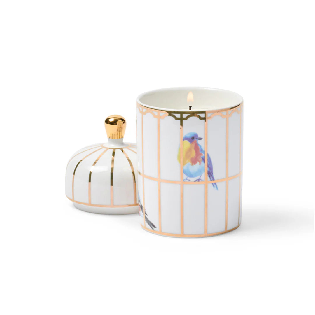 Decorative candle with bird design on a white background