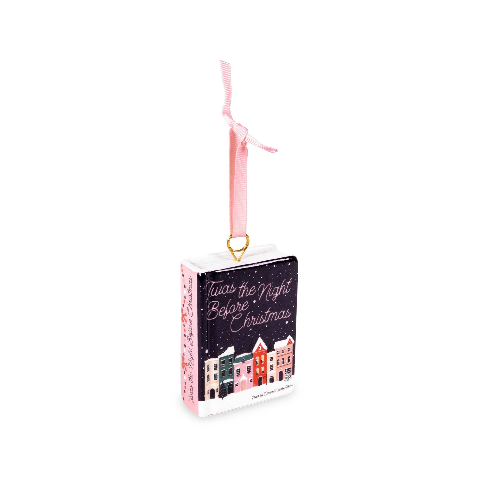 A Steel Mill brand small decorative book-shaped Christmas ornament with a pink ribbon loop and gold ring, featuring the phrase 'Twas the Night Before Christmas' and a row of colorful houses on a dark background.