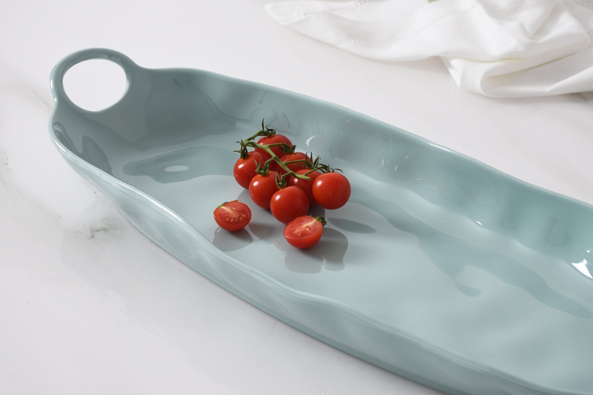 Light blue ceramic dish with cherry tomatoes on a white surface