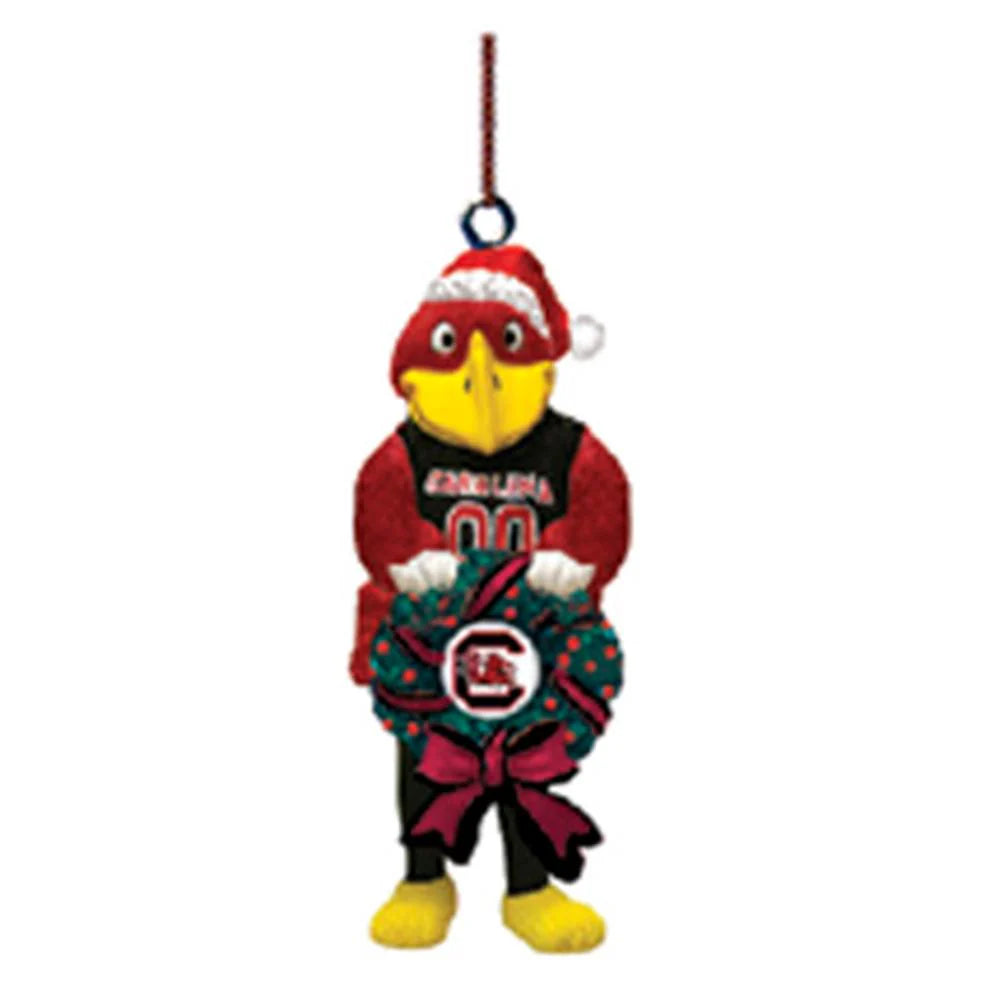 Plush bird ornament wearing a Santa hat and holding a wreath on a white background