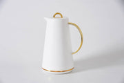 White ceramic pitcher with gold accents on a light gray background