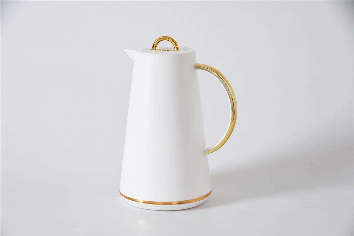 White ceramic pitcher with gold accents on a light gray background