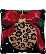 Decorative pillow with leopard print ornament and red bow on a black background