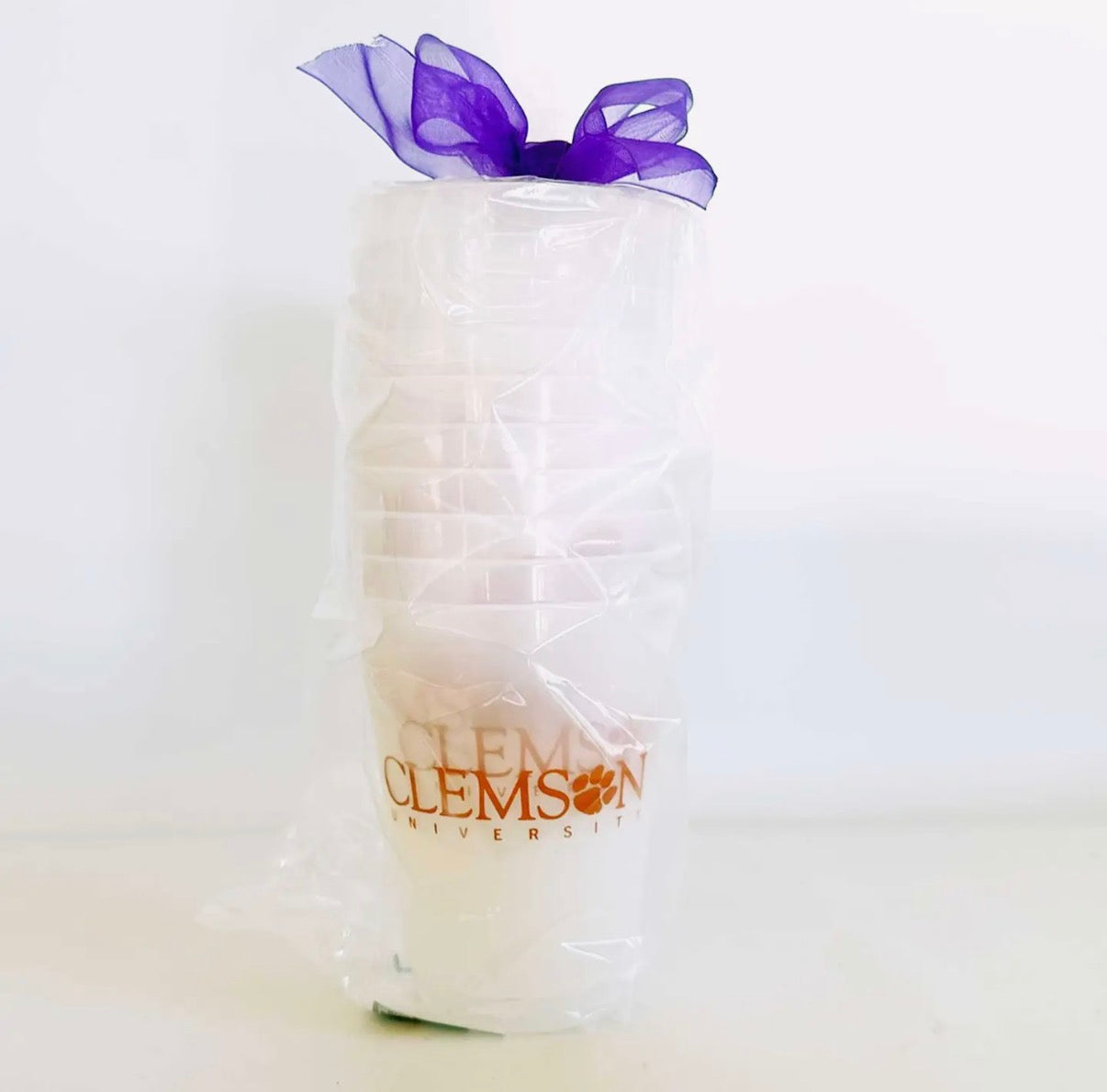 clear plastic reusable cups with Clemson University logo and purple bow on a white background