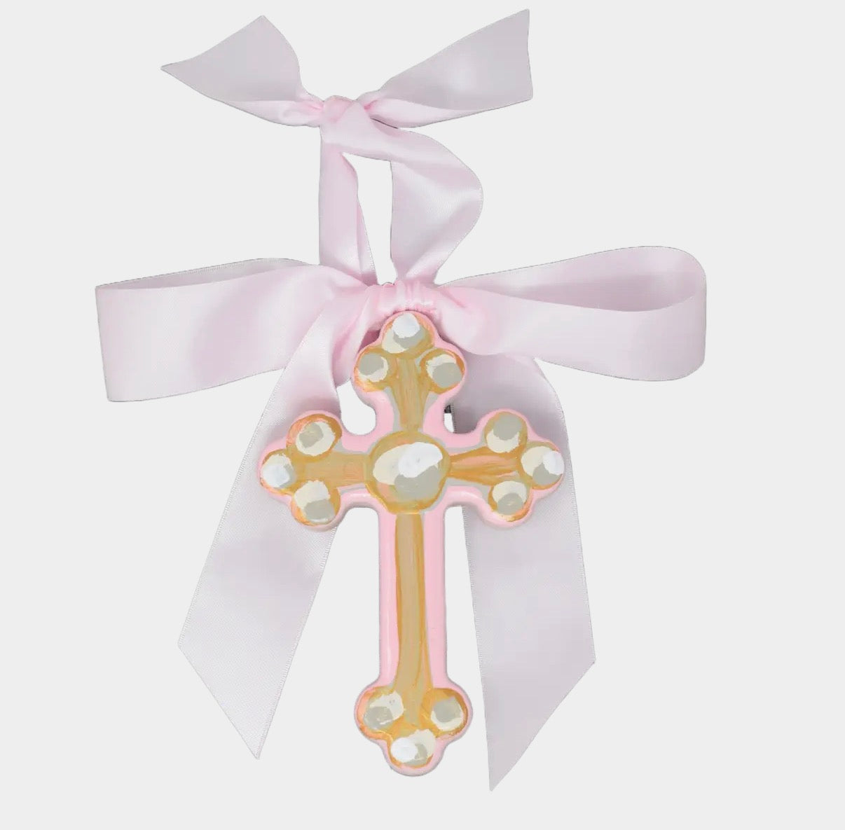 Decorative cross with pearls and a pink ribbon on a white background