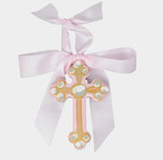 Decorative cross with pearls and a pink ribbon on a white background