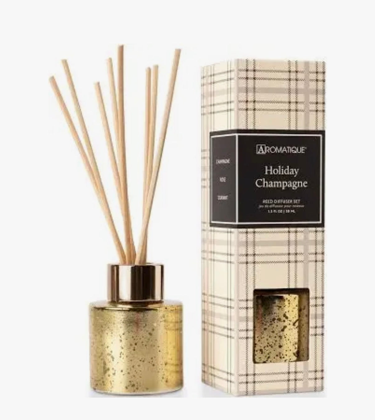 Aromatique reed diffuser in gold next to a decorative box 