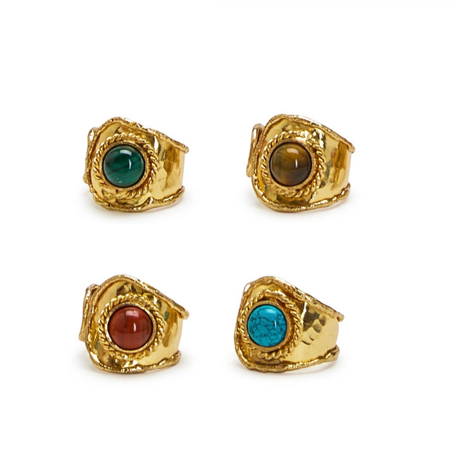 Four gold-rimmed rings with gemstones on a white background