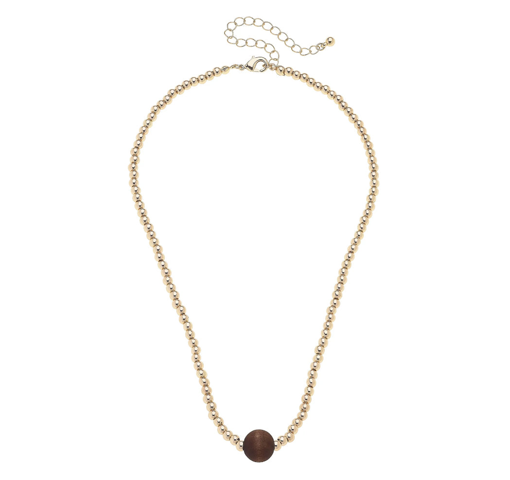 Gold necklace with a brown bead on a white background