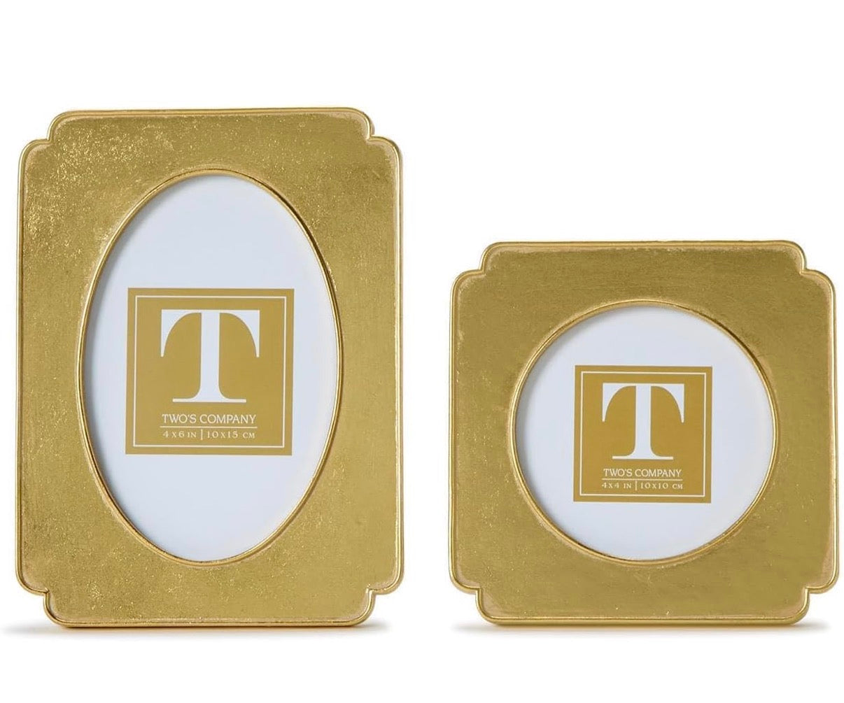 Two gold picture frames with a logo on a white background- Two’s Company Two gold picture frames with a logo on a white background