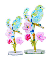 Colorful bird and flower decorations on clear stands against a white background