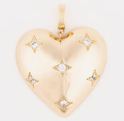 Gold heart-shaped pendant with star designs on a white background