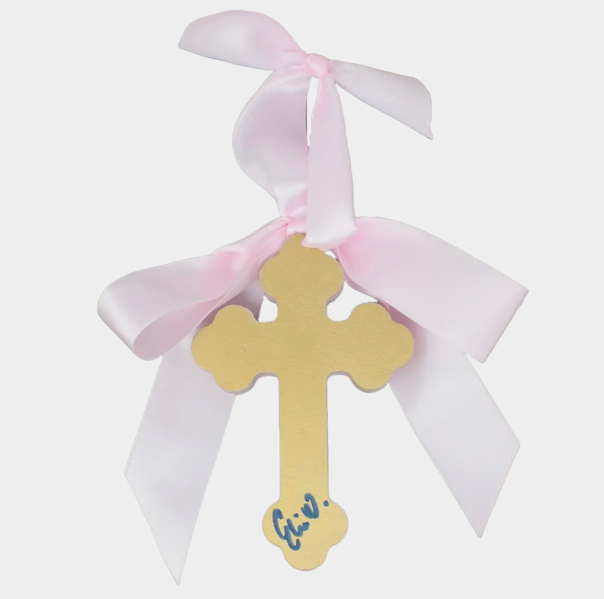 Gold cross with pink and white ribbons on a light gray background