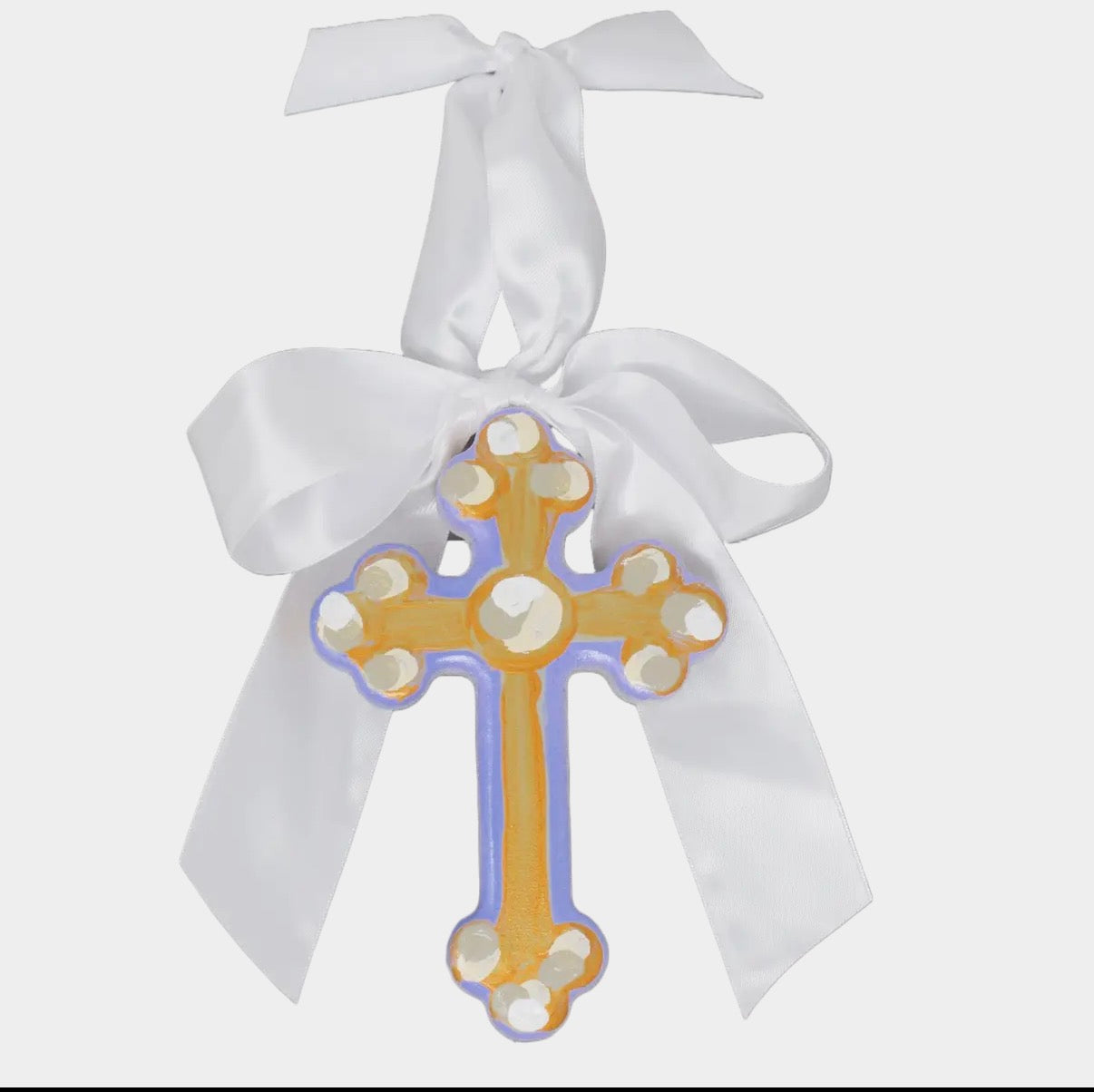 Decorative cross with white ribbon on a light gray background