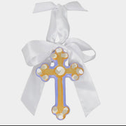 Decorative cross with white ribbon on a light gray background