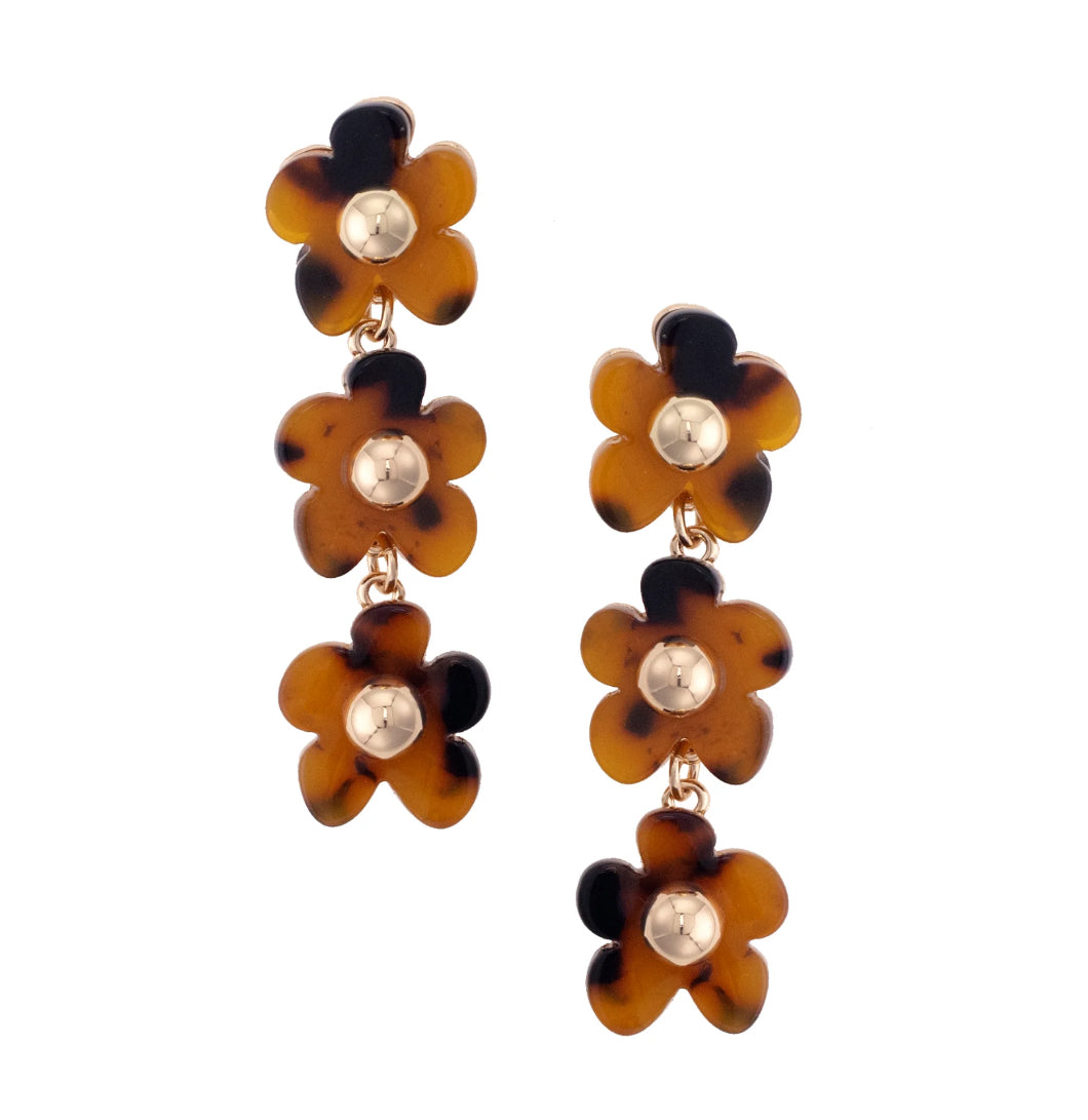 Pair of floral earrings with tortoiseshell and gold accents on a white background